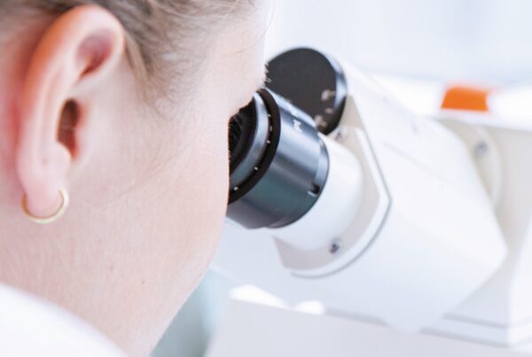 female laboratory worker looking into microscope